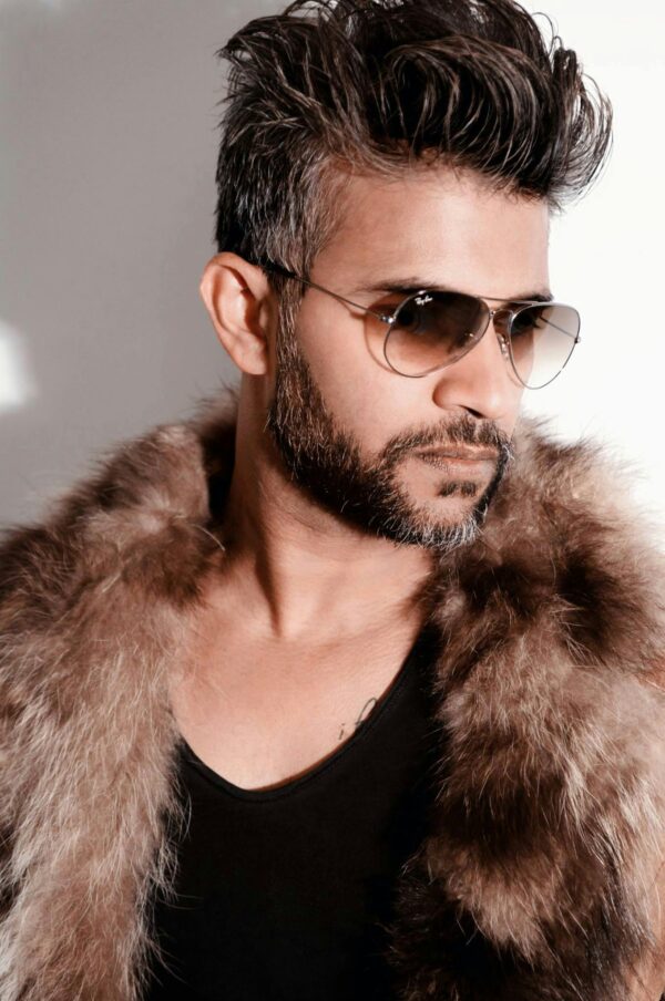 Fashion-forward man wearing a fur coat and sunglasses, exuding style.